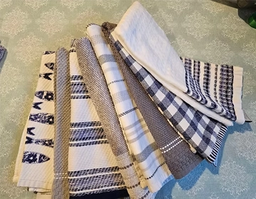 Clean striped kitchen towels folded and arranged for short-term vacation linen rentals in Jersey Shore